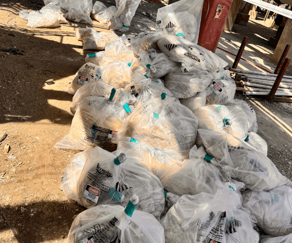 Collected asbestos waste sealed in approved bags during industrial asbestos abatement operations.
