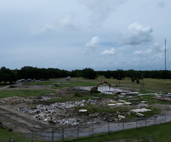 Wide aerial view of an industrial dismantling site showing cleared ground and early-stage site restoration.