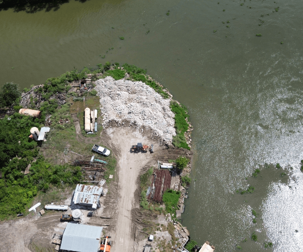 Dockside industrial area after dismantling, showing restored shoreline and managed site conditions.