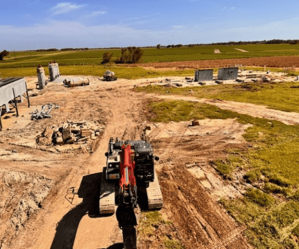Aerial view of an industrial site during active dismantling operations with equipment removal and material staging.