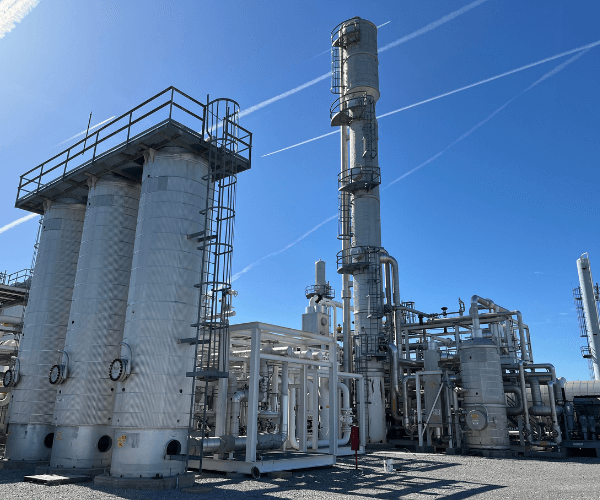 Industrial processing towers and structural equipment at a decommissioned plant undergoing recovery, recycling, and site cleanup operations.